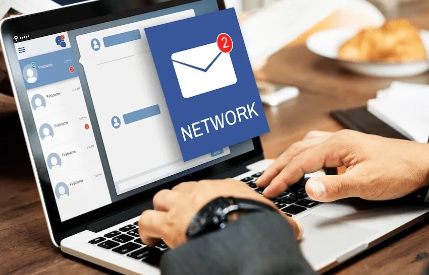 business setup services in uae -Person using a laptop with an overlay graphic of a message icon and the word 'NETWORK.'